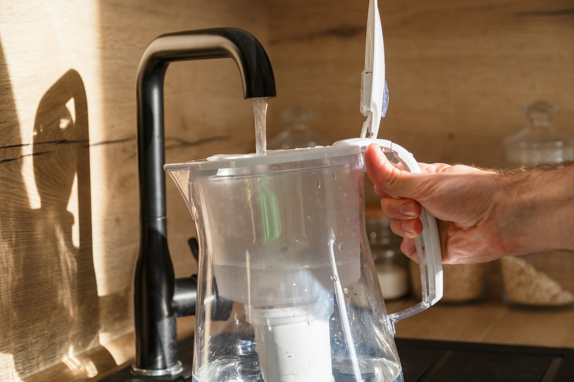 Water filter jug in kitchen sink, filling up.